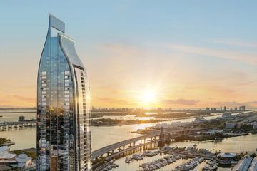 Rendering of Delano Residences and Hotel Miami, a slender glass tower over Biscayne Bay at sunset